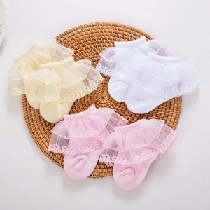 Baby cotton lace trim socks set in yellow, white and pink displayed on a woven mat