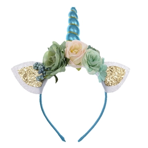 Dettaglio del cerchietto unicorno con corno blu a spirale e decorazioni di rose finte