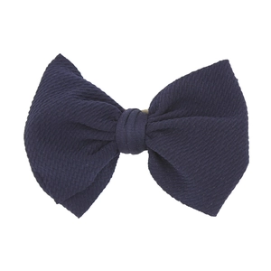Dettaglio del fiocco in nylon blu scuro che mostra la trama saia e il nodo centrale