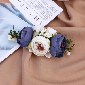 Detailansicht der pastoralen Haar-Accessoires mit blauen Seidenrosen auf Leinen