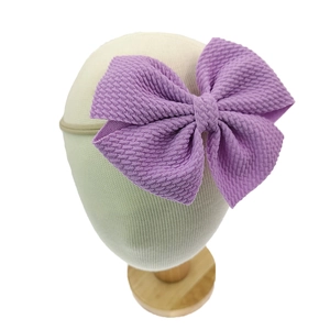 Detailansicht einer lila Waffelstoff-Schleife an einem weichen Baby-Stirnband für Mädchen