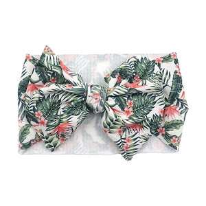 Detailed close-up of large bow baby headband with green tropical leaf and pink floral prints