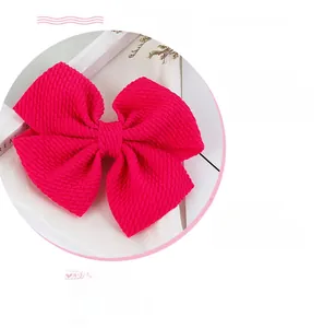 Detailed view of handmade pink grosgrain ribbon bow clip with ribbed fabric texture
