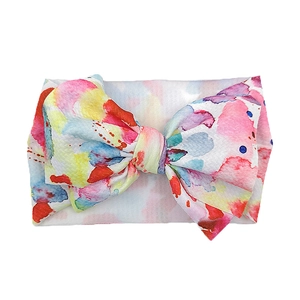 Detail of baby headband featuring large colorful watercolor print bow and elastic knit fabric
