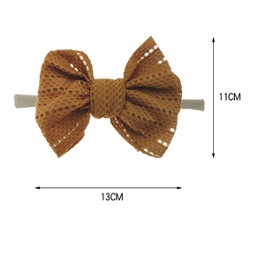 Detail view of brown lace bow baby headband with elastic nylon band and size annotations