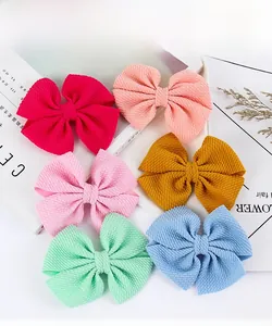 Detail of six waffle-textured fabric hair bows in various soft pastel candy colors