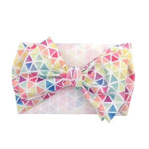 Detail of wide baby headband featuring colorful geometric prints and large bow knot