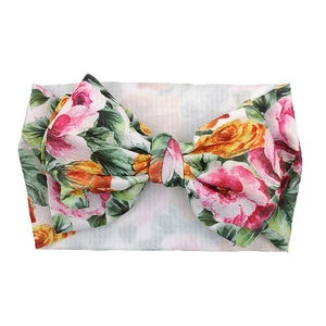 Close-up of floral bow headband for babies with pink and yellow rose prints