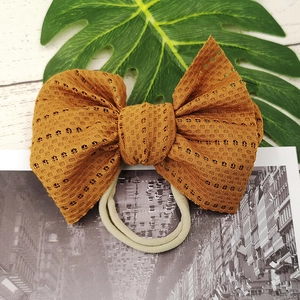 Detailed view of the ginger lace mesh bow texture on a soft nude nylon baby headband