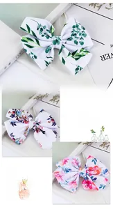 Close-up of three textile bow hair clips featuring floral and leaf patterns for kids