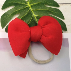 Detail of red oversized bow headband made of ribbed grosgrain fabric for kids