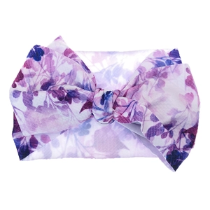 Detailed close-up of a wide floral baby headband with a large soft decorative bow