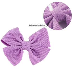 Close-up of purple bow hair clip featuring premium textured knit fabric for girls