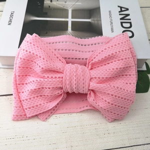 Detailaufnahme eines rosa Baby Stirnbandes aus Netzstoff mit einer großen doppelten Schleife