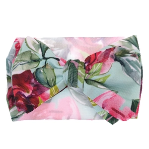 Detail of baby headband with large mint green bow and pink floral rose print patterns