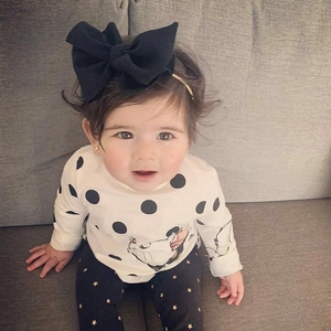 Detailed view of baby girl three-piece set with cat print top and bow headband