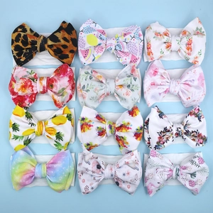 Flat lay of 12 assorted floral and leopard print baby headbands with soft elastic bands