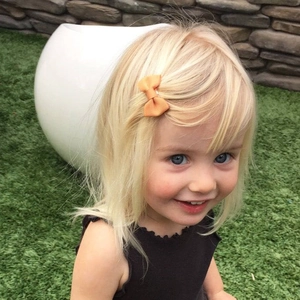 Détail d'une petite pince à cheveux avec nœud en ruban orange pour petite fille
