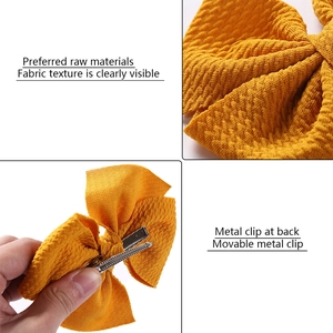 Detail of ginger fabric texture and silver metal clip on children's bow hair clip