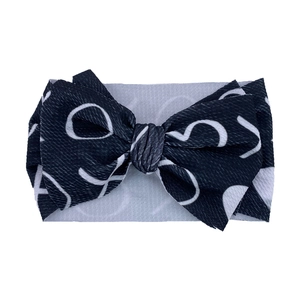 Detail shot of black and white waffle textured bow headband for baby girls