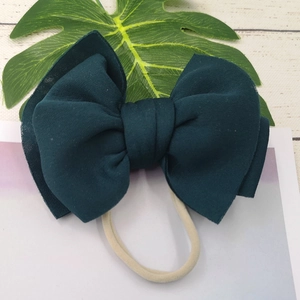 Detail of soft dark green oversized bow headband with stretch nylon band for infants