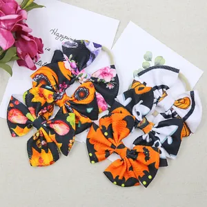 Close-up of Halloween bow headbands featuring pumpkin and ghost patterns on soft fabric