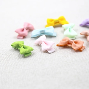 Détail de pinces à cheveux en ruban gros-grain couleurs macaron pour petites filles