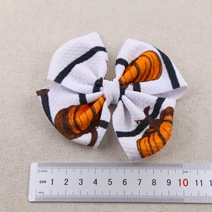 Detail view of 9cm Halloween pumpkin striped hair bow with ruler for size reference