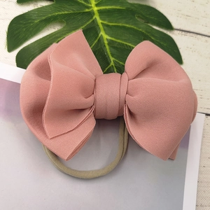 Detailed close-up of a 3D padded bow headband in dusty pink for baby girls hair decor