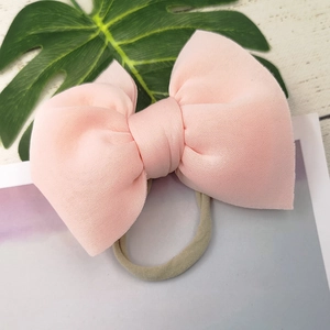 Detail of pink puffy bow headband for infants with high-elasticity nylon band