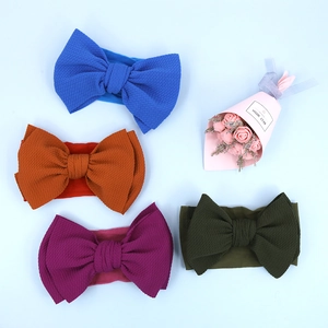 Set of four soft elastic nylon headbands with large textured corn grain bow detail