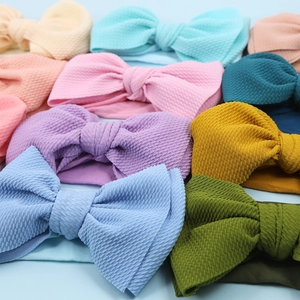 Detailed waffle texture and vibrant colors of handmade bow headbands for babies