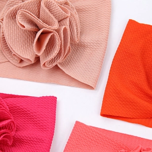 Gros plan de bandeaux pour bébé en tissu texturé avec de grandes fleurs 3D décoratives