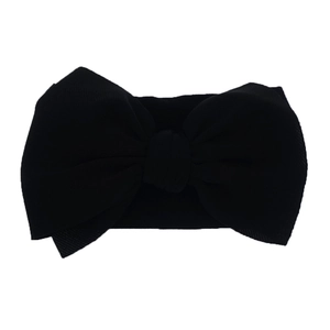 Detail shot of a soft black nylon headband for babies with a large oversized bow