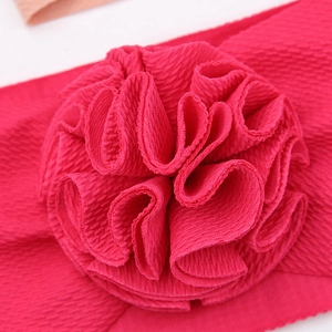 Gros plan du bandeau bébé rose avec texture gaufrée et grande fleur tridimensionnelle