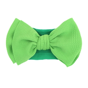 Detail of soft green nylon headband with textured corn kernel bow for infants and girls