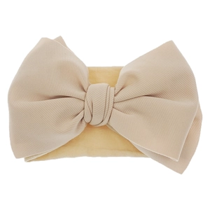 Close-up of beige baby nylon headband featuring a large textured fabric bow design