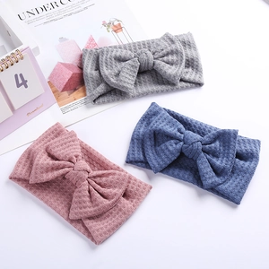 Détail de la texture gaufrée des bandeaux à nœud pour bébé en gris rose et bleu ciel