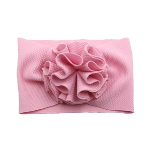 Détail d'un bandeau rose gaufrette pour bébé avec une grande fleur plissée 3D multicouche