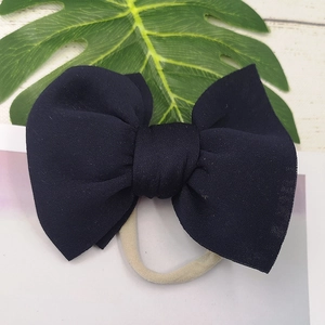 Detail of navy blue puffy bow headband with soft high-elastic nylon strap for infants