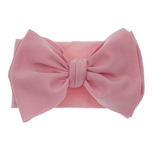 Detailed macro view of pink nylon headband featuring a large textured fabric bow