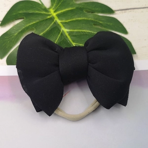 Detail view of black 3D puff space cotton bow headband with soft nylon elastic band for babies