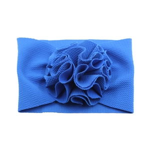 Détail macro du bandeau élastique bleu foncé avec maille texturée et accent floral 3D
