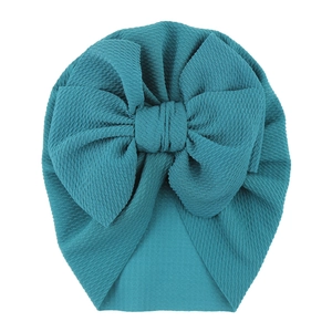 Detail shot of peacock blue waffle knit texture on a baby turban hat with oversized bow