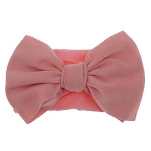 Detailed view of the fine ribbed texture on a dusty pink nylon baby bow headband