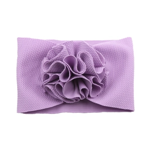 Détail d'un bandeau violet pour bébé en maille gaufre avec une grande fleur 3D plissée