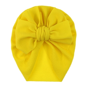 Detail showing the bubble texture and large bow on this yellow baby turban hat