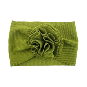 Vue détaillée d'un bandeau pour bébé en maille gaufre vert herbe avec fleur en tissu