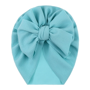Detail of baby turban hat featuring a large bow and light blue waffle knit texture