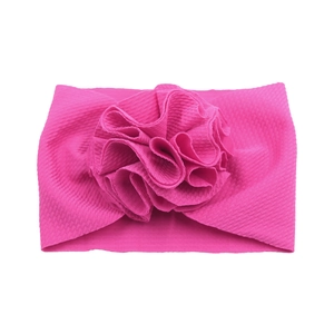 Détail de bandeau bébé à texture gaufrée avec grande fleur plissée en tissu rose foncé